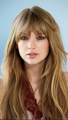 a woman with long blonde hair and blue eyes wearing a lace top looking at the camera