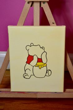 a small wooden easel with a cartoon bear on it