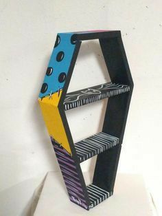 a sculpture made out of cardboard and painted with black, blue, yellow and purple shapes