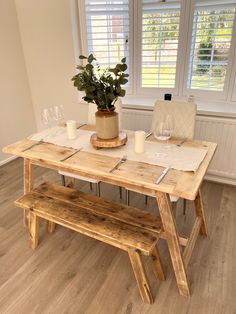 a wooden table with two benches next to it and a potted plant on top