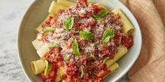 a bowl filled with pasta covered in sauce and parmesan cheese