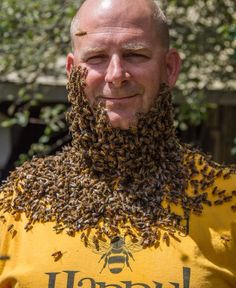 a man with a beard covered in bees