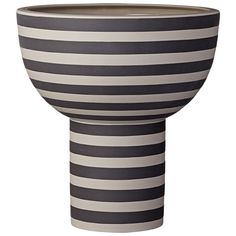 a black and white striped vase sitting on top of a table