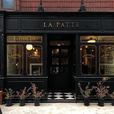 the front entrance to lapatte restaurant with potted plants outside