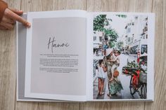 an open photo book with people walking on the street and one person pointing at it