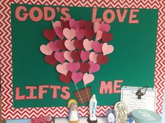 a bulletin board with hearts in a basket on it and the words god's love lifts me up