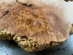 a close up of a wooden table with gold leafy woodgrains on it