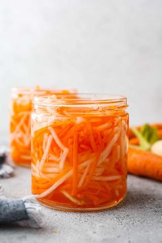 carrots and other vegetables are in jars on the counter next to each other, ready to be cooked