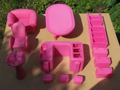 a pink plastic furniture set sitting on top of a cardboard box