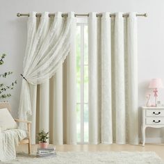 a living room with white furniture and curtains