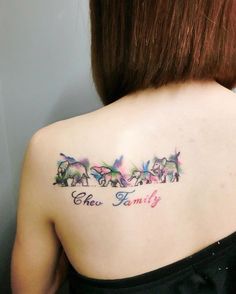 the back of a woman's shoulder with three dogs and their name on it