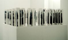 an art installation with black and white images on the wall, in front of a mirror