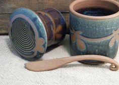 two ceramic cups and a wooden spoon on a table