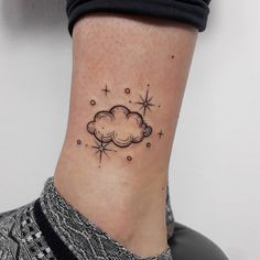 a woman's ankle with a small cloud and stars tattoo on her left side