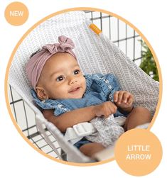 a baby sitting in a shopping cart wearing a blue dress and pink headband with the words little arrow on it