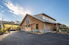 a large wooden building sitting on the side of a road next to a fenced in area