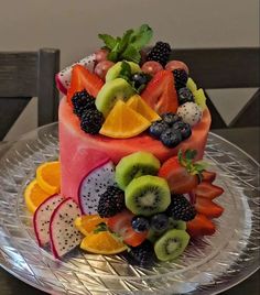 a cake with fruit on it sitting on top of a glass plate