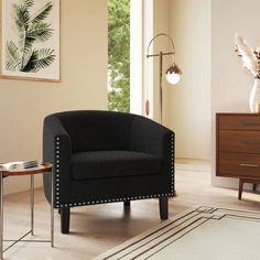 a living room with a black chair and white rug