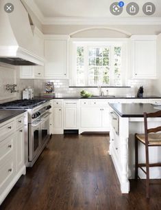 a kitchen with white cabinets and wood floors