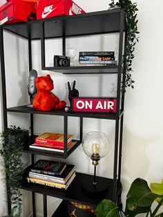 there is a shelf with some books on it and a red teddy bear in the corner