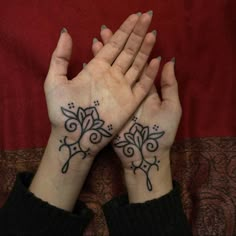 two hands that have tattoos on them