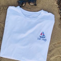 Hand Embroidered Sailboat And Quote. Colors Are Red, Navy Blue And Dusty Blue. Comment If You Would Like Custom Colors. Blue Nautical Style T-shirt For Summer, Sail Color Cotton Short Sleeve Tops, Casual Short Sleeve Sail Tops, Nautical Cotton T-shirt For Summer, Nautical Blue T-shirt For Summer, Blue Nautical T-shirt For Summer, Beach Embroidered Short Sleeve T-shirt, Embroidered Short Sleeve Beach T-shirt, Embroidered Short Sleeve T-shirt For Beach