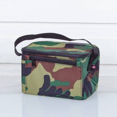 a camo print lunch bag sitting on top of a white table next to a wall