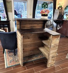 a wooden desk with an open drawer on the side and a chair next to it