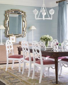 a dining room with blue walls and white furniture