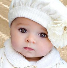 a baby wearing a white hat and coat