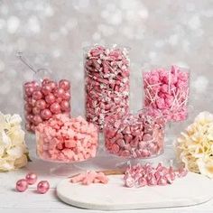 some pink and white candies are on a table next to hydrangea flowers