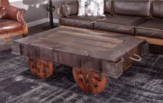 a coffee table made out of an old trunk with wheels on the bottom and leather upholster