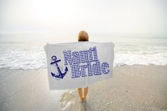 a woman holding a towel with an anchor on it