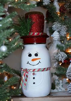 a snowman jar sitting on top of a shelf next to a christmas tree with lights