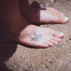 a person with a bird tattoo on their left foot and the bottom part of her leg