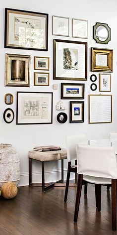 a dining room table with chairs and pictures on the wall