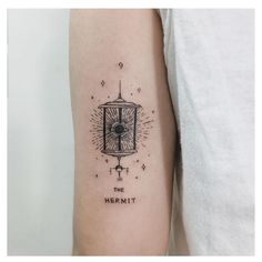 a person with a tattoo on their arm that reads, the hermit and has an eye in it