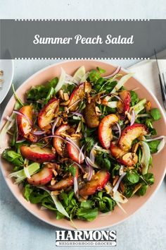 a pink plate topped with salad and sliced peaches