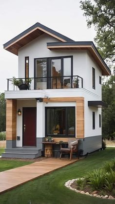 a white house with black trim and wood accents on the front door, windows, and balcony