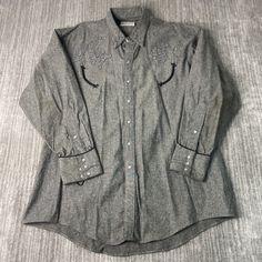 Vintage 80s Ranch Wear Western Cowboy Stitched Embroidered Pearl Snap Streetwear Grey Button Up Collar Shirt Double Extra Large Mens Condition: Fair Used Condition = Has flaws on the sleeve due to wear and age. Measurements: Please see photos above for all measurements IF YOU BUY TWO OR MORE ITEMS USE THE CODE BUNDLE @ CHECK TO SAVE 20% WE SHIP WITHIN 24 HOURS AFTER PURCHASE! Please be aware that we do not offer free returns!! The Buyer is responsible for the cost of the return label.  Follow us on TikTok & Instagram @findsnostalgic and tag us in your finds Winter Embroidered Button-up Tops, Embroidered Button-up Western Tops, Western Style Embroidered Button-up Top, Western Long Sleeve Top With Floral Embroidery, Classic Long Sleeve Embroidered Shirt, Classic Embroidered Button-up Shirt, Embroidered Collared Winter Tops, Western Long Sleeve Embroidered Shirt, Retro Embroidered Button-up Top