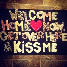 a sign that says welcome home, get over here and kiss me on the floor