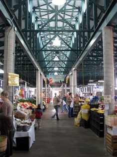 an indoor market with people shopping for produce