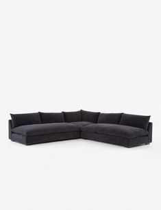 a black sectional couch with pillows on it's back and the seat folded out