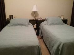 two twin beds in a hotel room with blue sheets and pillows on the bedding