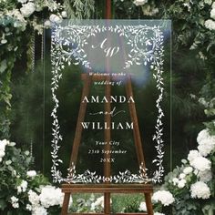 a wooden easer with white flowers and greenery around it is the perfect way to display your wedding program