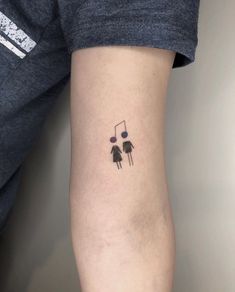 a person with a black and white tattoo on their arm holding a music note in front of them