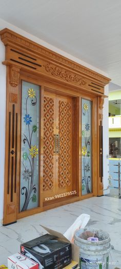 a wooden door with decorative glass panels on it's sides and flowers painted on the doors