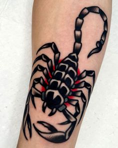 a black and white scorpion tattoo on the arm with red light coming from its claws