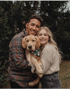 a man and woman holding a dog in their arms