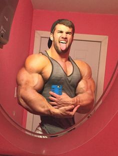 a man taking a selfie in the mirror with his arms crossed and muscles exposed